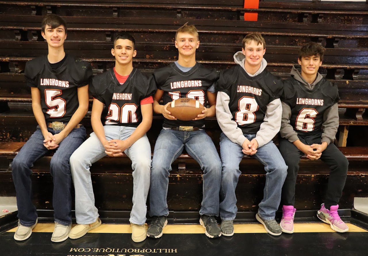 5 players sitting on the front row of bleachers